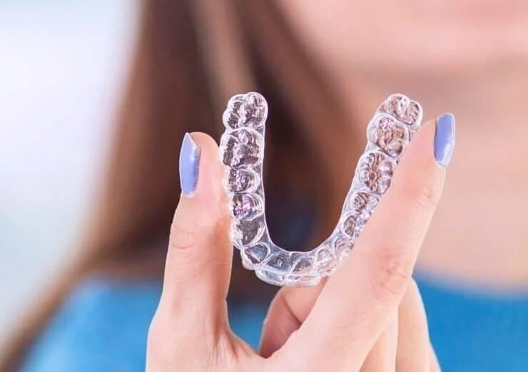Young woman smiling while wearing clear aligners